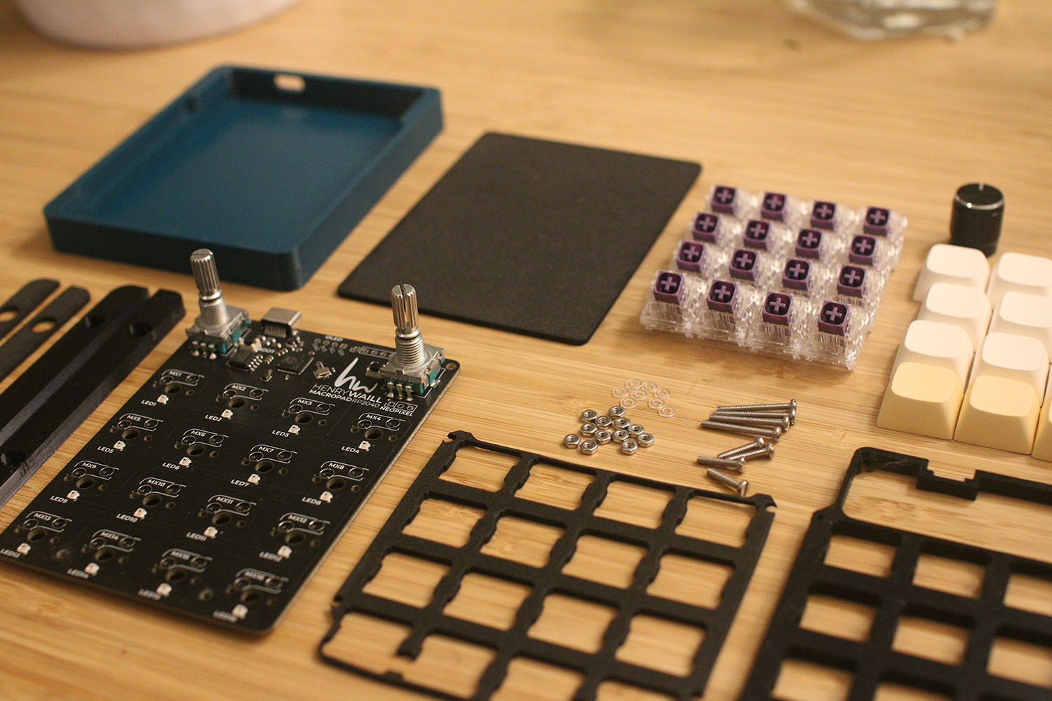 All components needed to construct the macropad are laid out neatly on a desk.